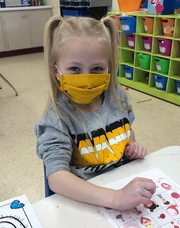 student wearing a mask while coloring 