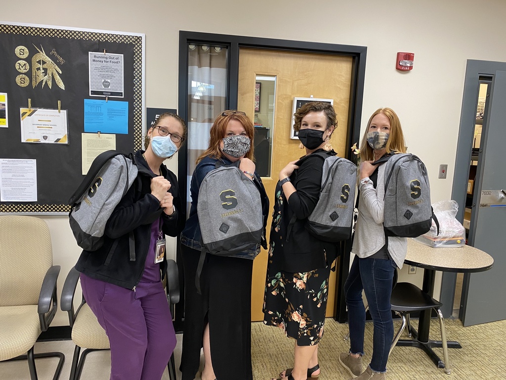 Middle School office staff with backpacks