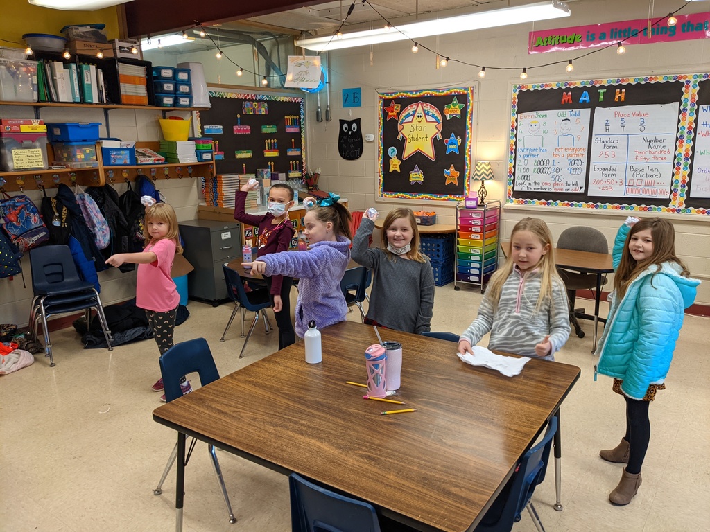 group of second graders throw paper snow balls across the classroom