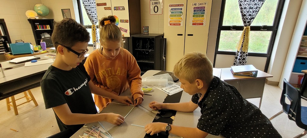 3 students building with staws