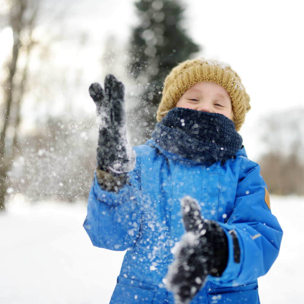 child wiping snow off of their gloves