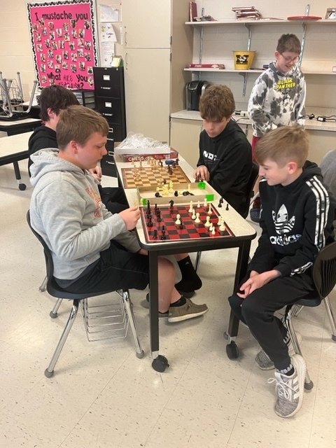 four students play chess 